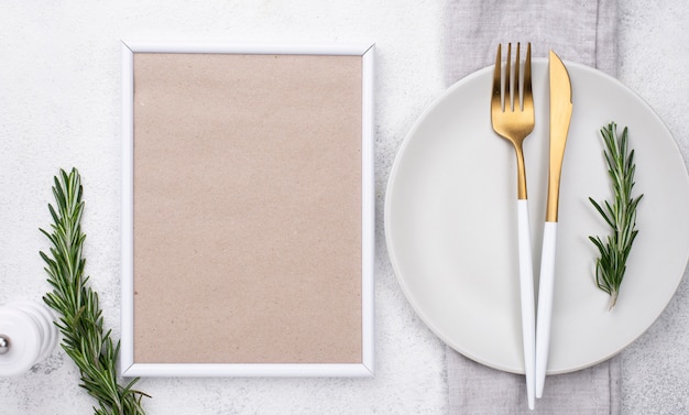 Plate with cutlery and frame on table