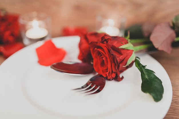 Free photo plate with cutlery and roses close up