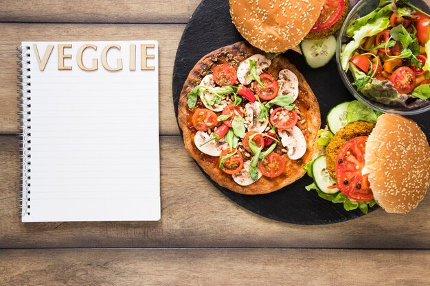 Plate with delicious veggie food next to notebook