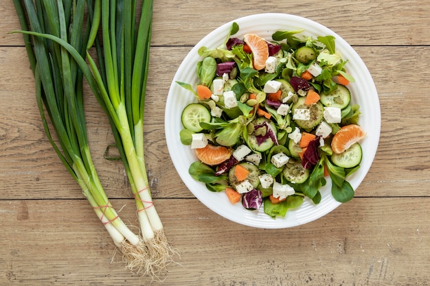 Plate with fresh salad on table