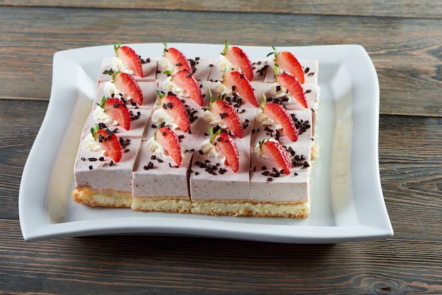 Free Photo plate with sliced cheesecake decorated with chocolate crust and strawberries placed on wooden table restaurant cafe coffee shop bakery baking cooking pastry sweer dessert concept.