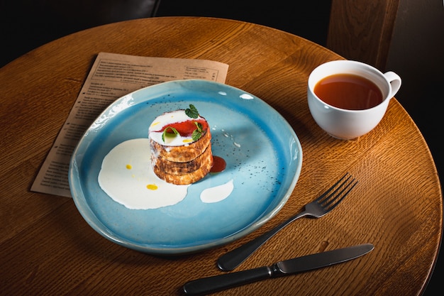 Plate with tasty pancakes on wooden table