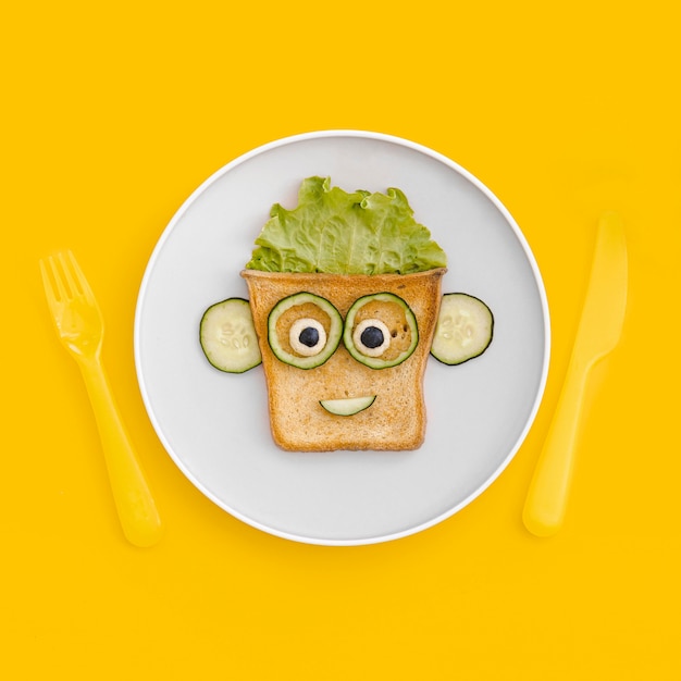 Free Photo plate with toast face shape with apple on table