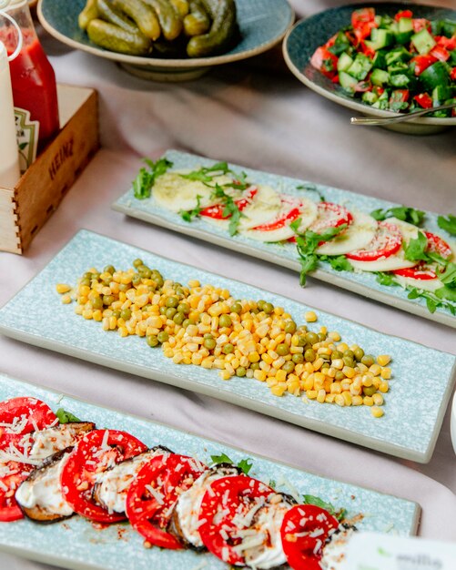 plates of corn and tomatoes with cheese and eggplants