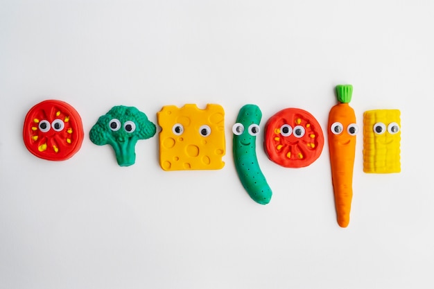 Free photo play dough background with vegetables top view