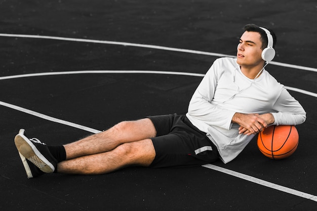 Player leaning on basketball full shot