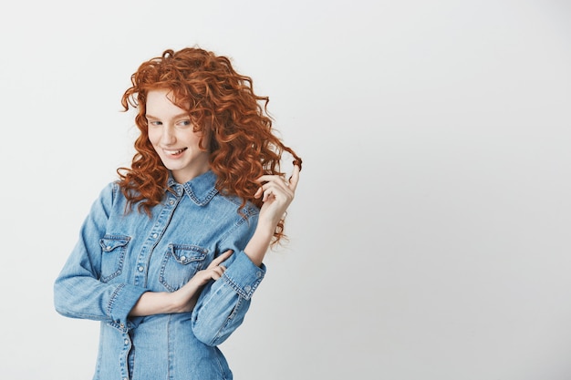 Free photo playful beautiful girl with foxy red hair thinking dreaming biting lips .