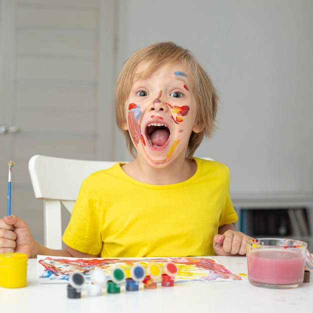 Playful boy painting