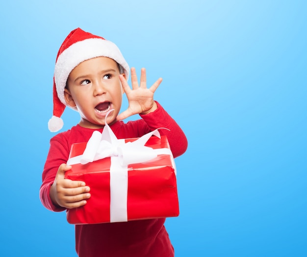 Playful child showing his present with blue background