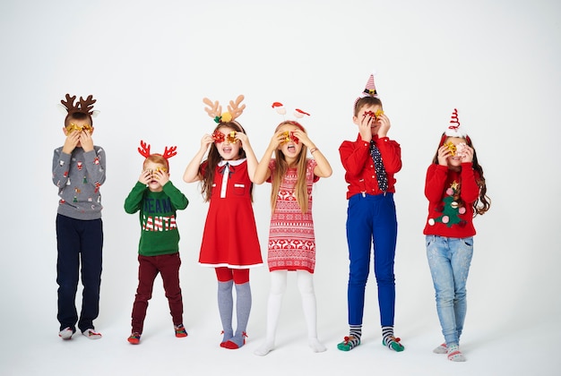 Free photo playful children holding bow in front of eyes