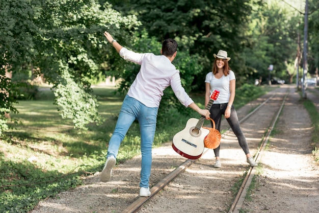 Playful couple walking on a railway