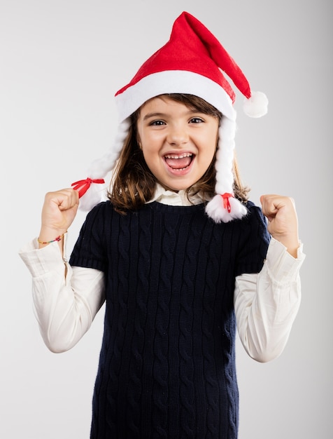 Free photo playful girl wearing a santa hat