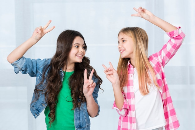 Playful girls showing peace sign