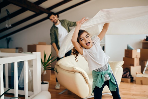 Free photo playful little girl having fun with her father at their new home