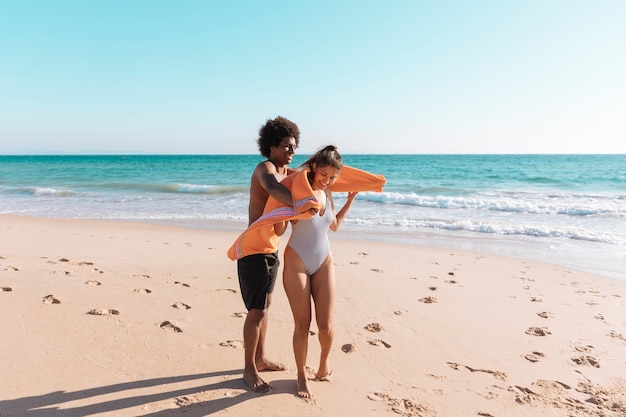 Playful multiethnic couple on beach