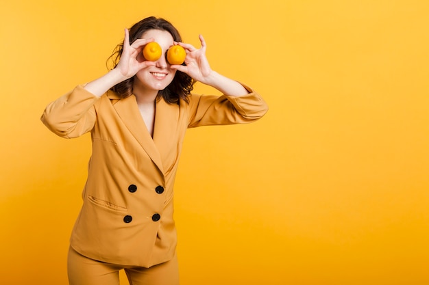 Free photo playful woman covering eyes with lemons