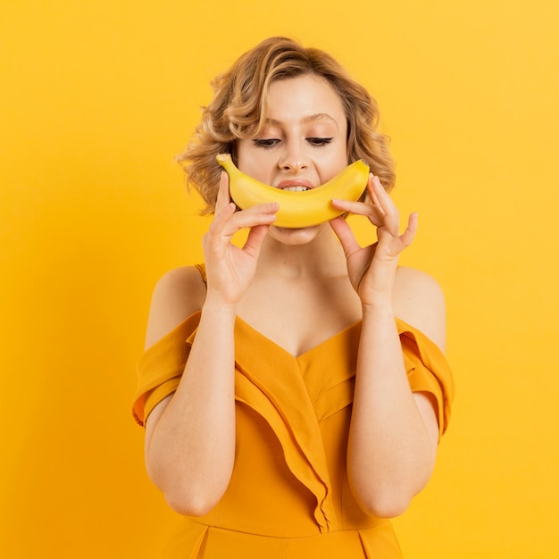 Playful woman eating banana