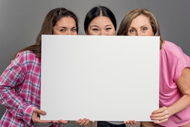 Playful woman hiding under blank paper sheet