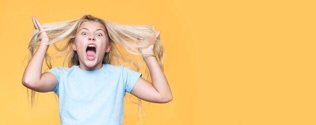 Playful young girl with yellow background