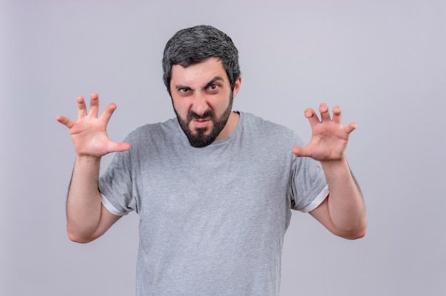 Playful young handsome caucasian man doing tiger roar and paws gesture isolated on white background