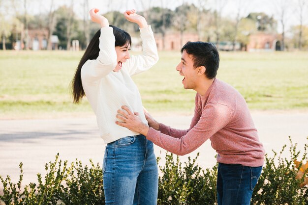 Playful young man tickling woman