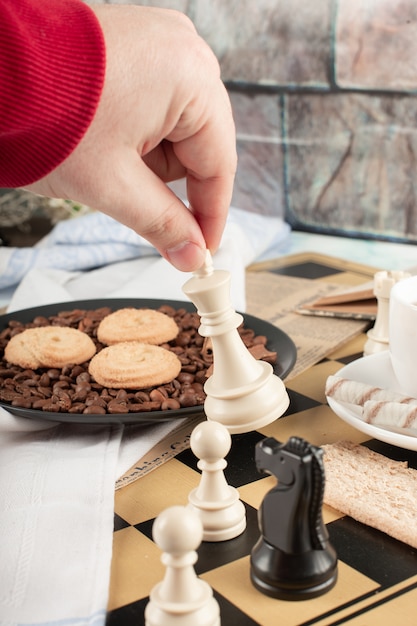 Free photo playing chess on a tea cookie table