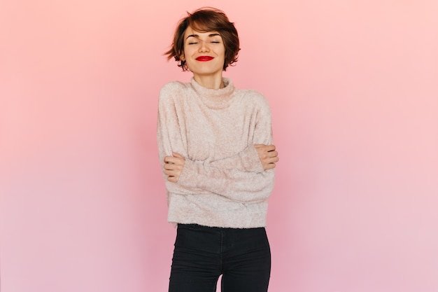 Free photo pleasant woman in sweater posing with closed eyes