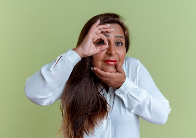 pleased casual caucasian middle-aged woman showing look gesture and putting hand on chin