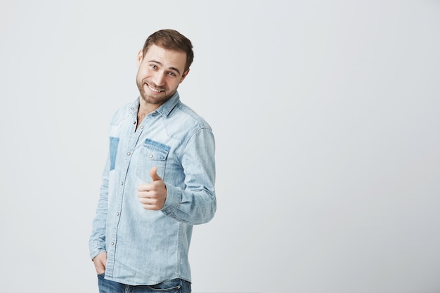 Pleased cheerful bearded man show thumb-up