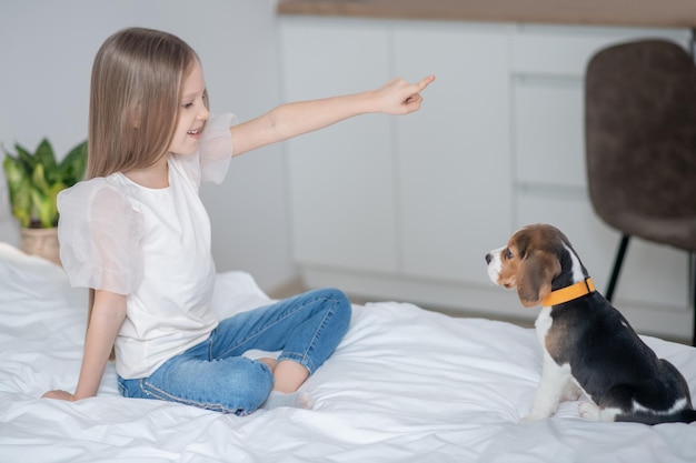 Pleased female child practicing a new command with a puppy