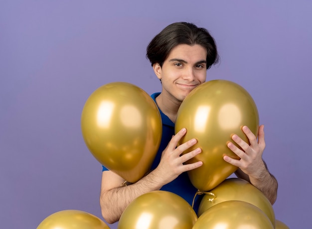 Pleased handsome caucasian man stands with helium balloons 