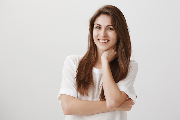 Pleased relaxed woman touching neck and smiling, got rid of pain