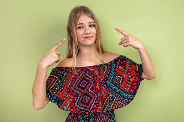 Pleased young blonde woman pointing at herself 