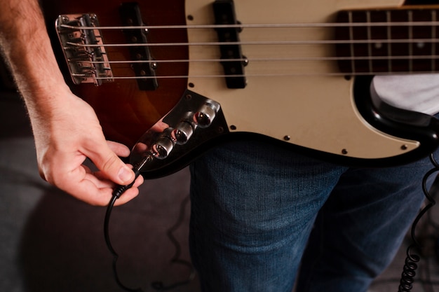 Free photo plugging the cable in the electric guitar