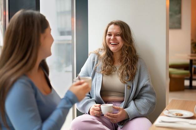 Plus-size female friends spending time together at a restaurant