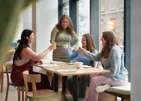 Free photo plus-size female friends spending time together at a restaurant