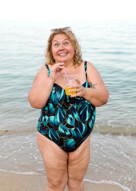 Free photo plus size model standing at the beach