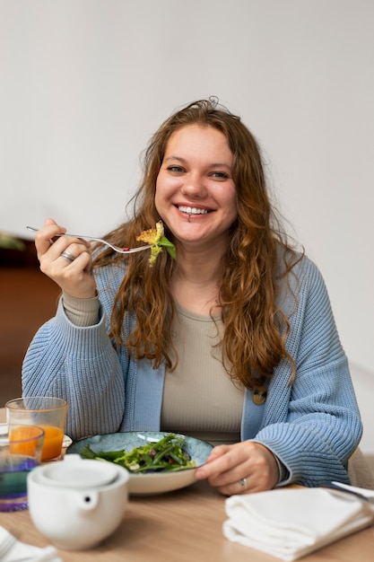 Free Photo plus-size woman eating at a restaurant alone