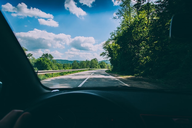 Point of view shot of a person driving a vehicle on the countryside road