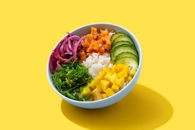 Poke bowl with rice, salmon,cucumber,mango,onion,wakame salad poppy seeds ands sunflowers seeds