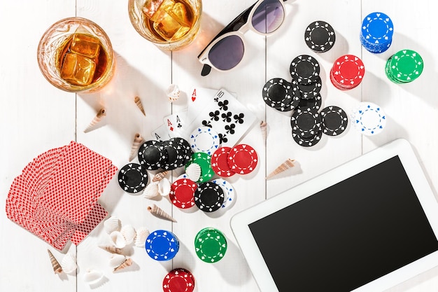 Poker. Set to playing poker with cards and chips on white wooden table, top view. Copy space