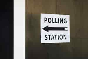 Free photo polling station sign with direction on wooden wall