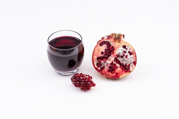 Pomegranate juice and pomegranate isolated on white surface