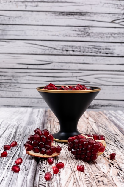 pomegranate seeds in plate on wooden table