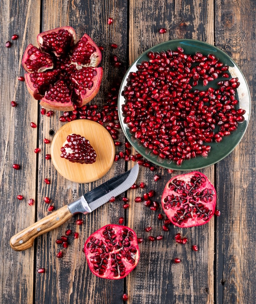 pomegranate top view with knife on wooden table