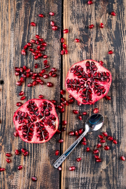 Free photo pomegranate top view with spoon on wooden surface