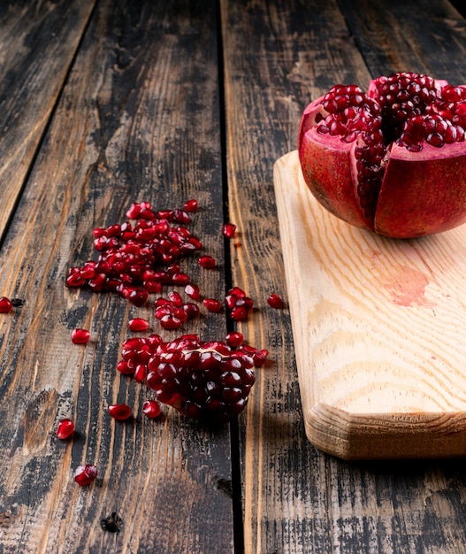 pomegranate on wooden cutting board on table