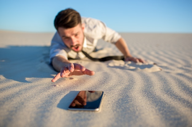 Free photo poor signal. businessman searching for mobile phone signal in desert