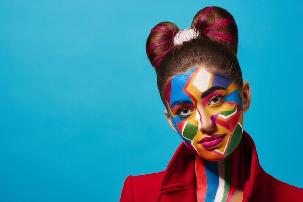 Pop art portrait of model wearing colorful figures on her face