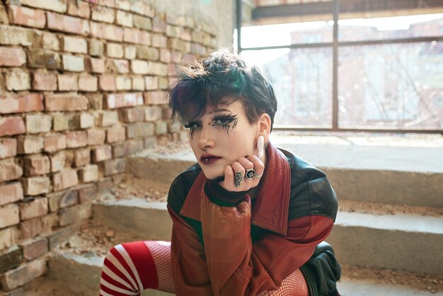 Pop punk aesthetic portrait of woman posing inside building on stairs